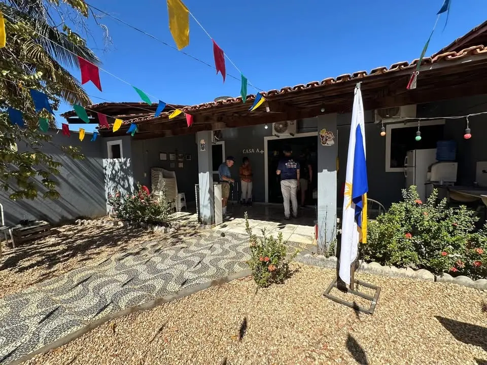 Fachada da sede da Casa A+ em Palmas, com bandeiras coloridas e pessoas reunidas